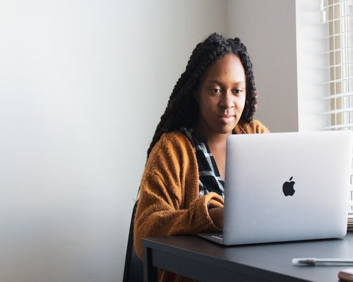Person looking away from their laptop out a window