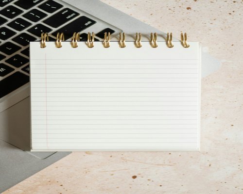 Notebook with a to-do list next to a keyboard
